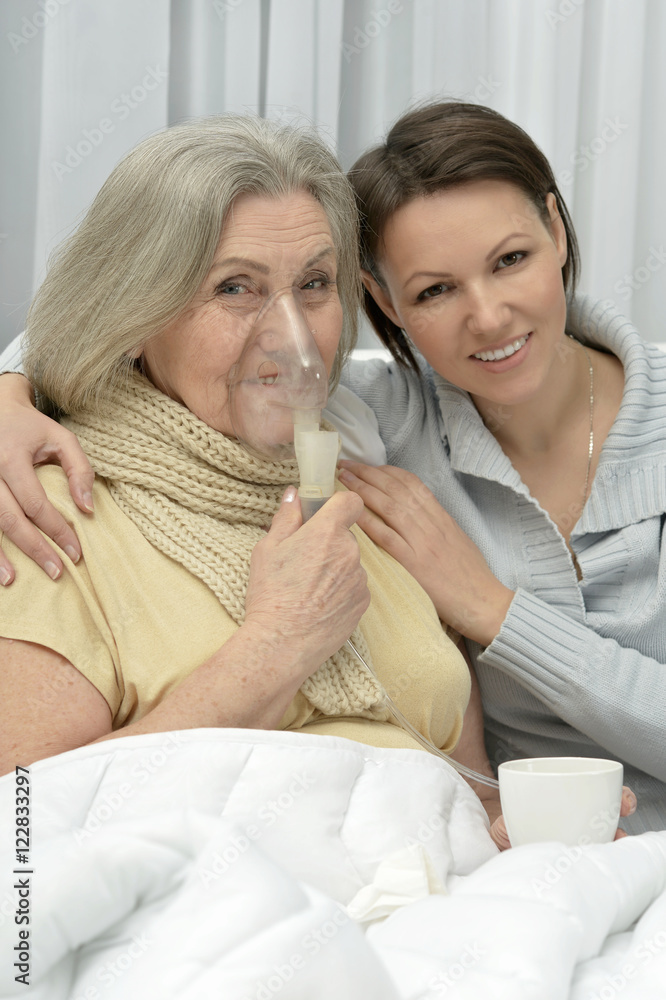 Senior ill woman with caring daughter