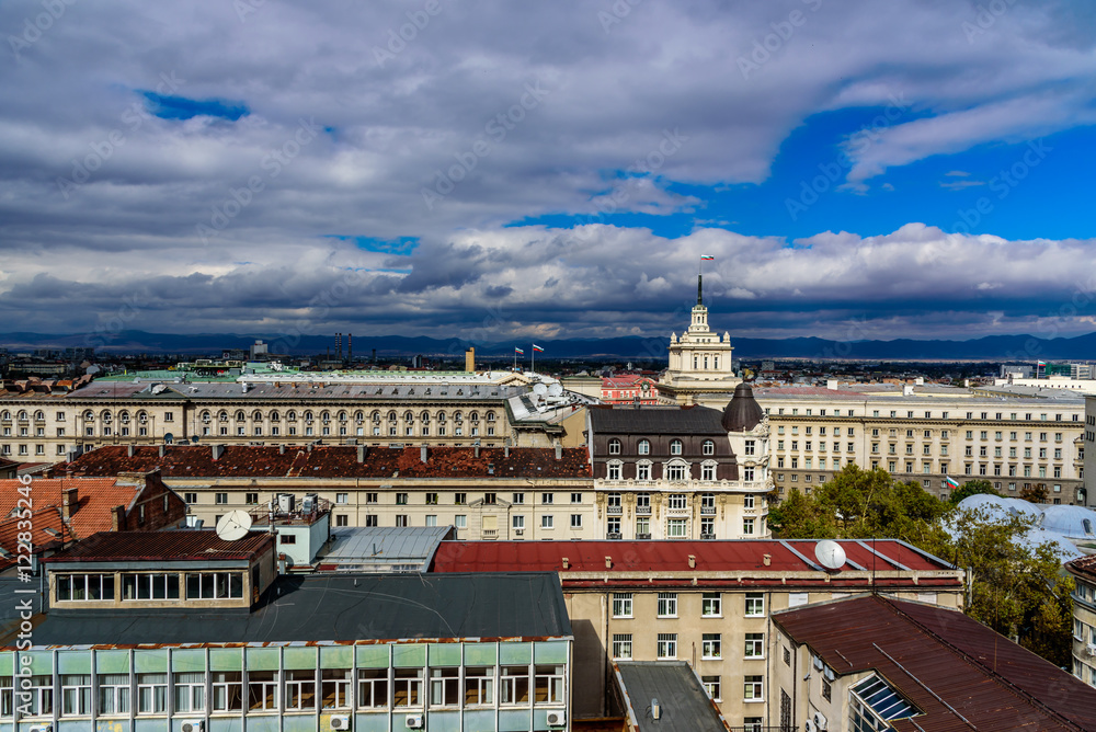 Buildings in downtown city center of Sofia, Bulgaria - wide shot from a roof top - periodical architecture with the Parliament building and the Bulgarian flag