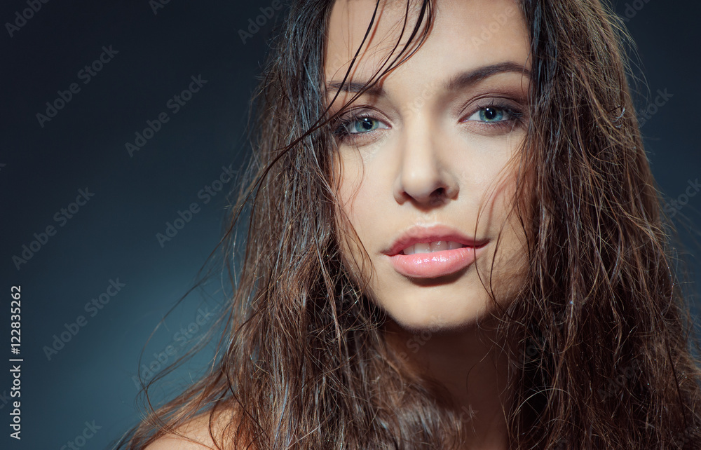 Fototapeta premium Sexy beauty. Close-up studio portrait of young fashion model with beautiful blue eyes looking at camera.