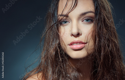 Sexy beauty. Close-up studio portrait of young fashion model with beautiful blue eyes looking at camera.