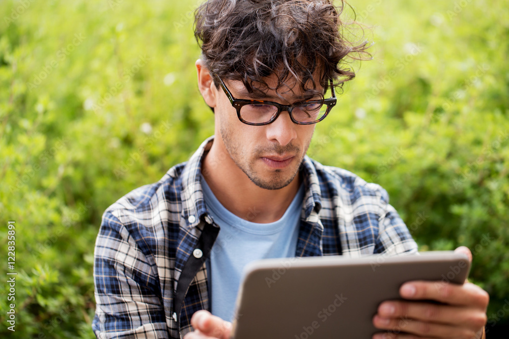 man in glasses with tablet pc computer outdoors