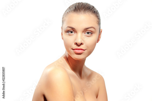 Natural as she is. Portrait of beautiful young shirtless woman looking at camera while standing against white background