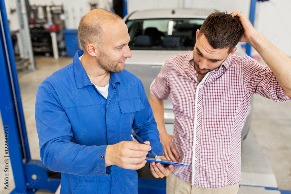 Fototapeta premium auto mechanic with clipboard and man at car shop