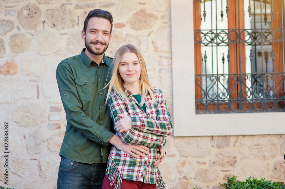 Happy to be together. beautiful young multi ethnic loving couple standing outdoors together while man hugging his girlfriend and smiling Happy to be together. beautiful young multi ethnic loving couple standing outdoors together while man hugging his girlfriend and smiling
