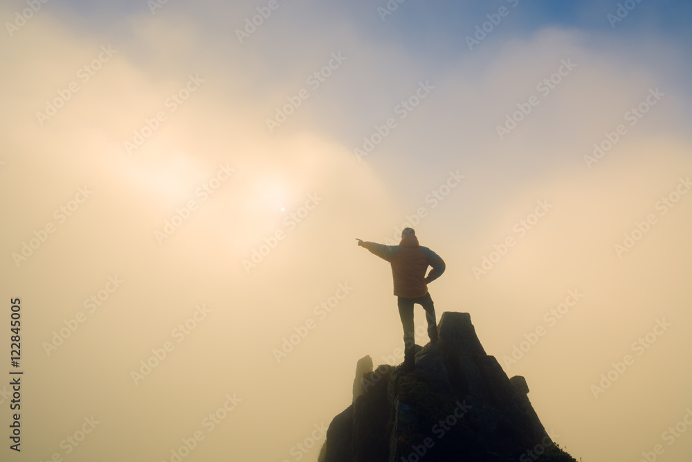 Hiker points to the sunrise