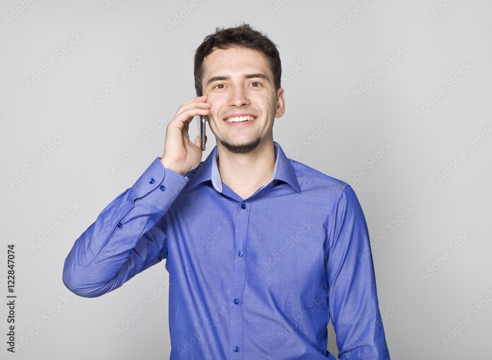 Handsome businessman in blue shirt talking on cellphone Handsome businessman in blue shirt talking on cellphone