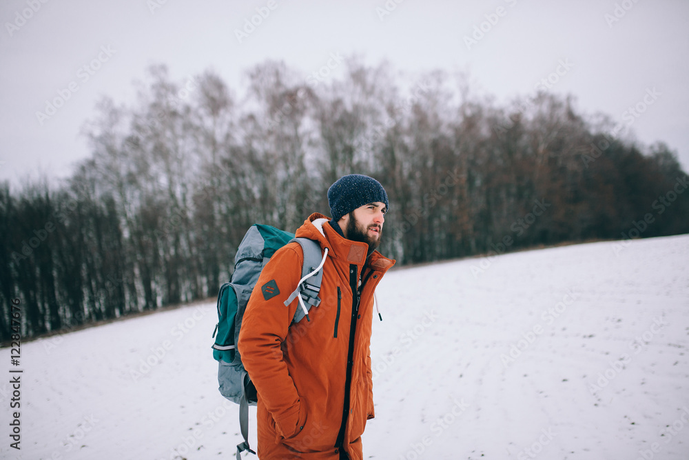 hiker walking on snow in the winter forest