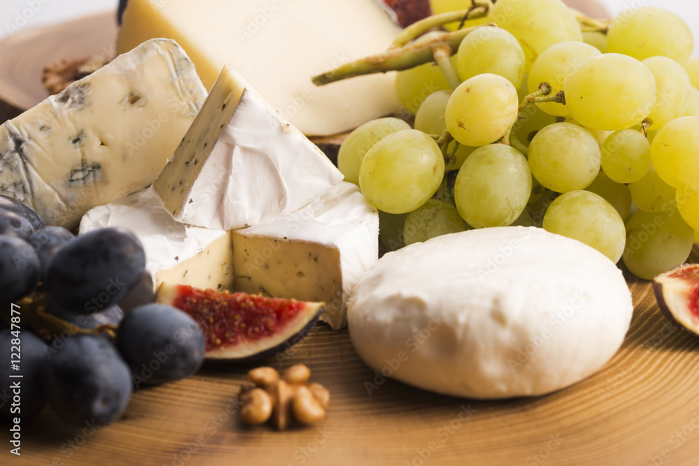 Assortment of cheese with fruits and grapes