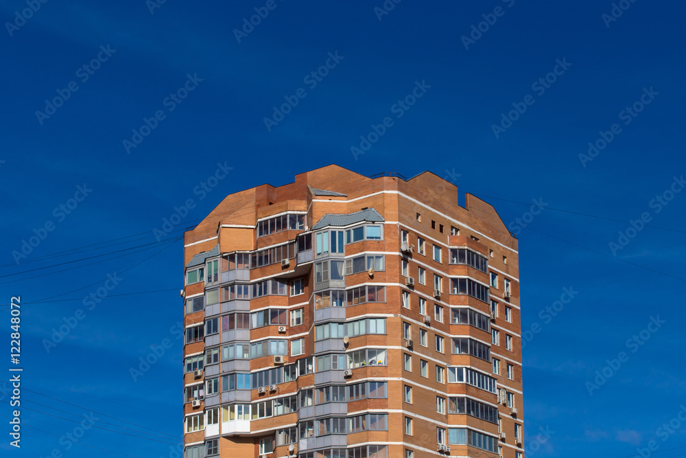 Apartment building against blue sky. Top- a place for your text.