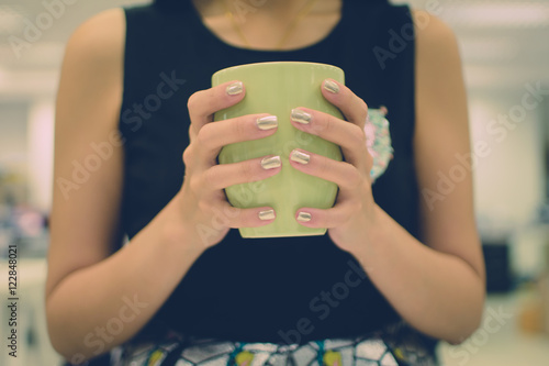 Cup in female hands © kukalek