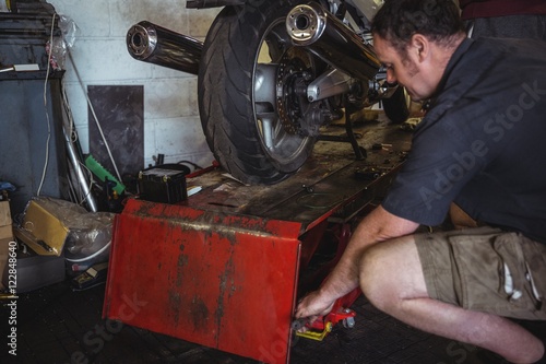 Mechanic using hydraulic lift photo