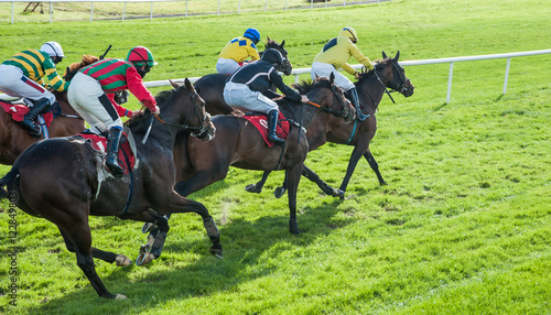 Race horses and jockeys sprinting  towards the finish line photo