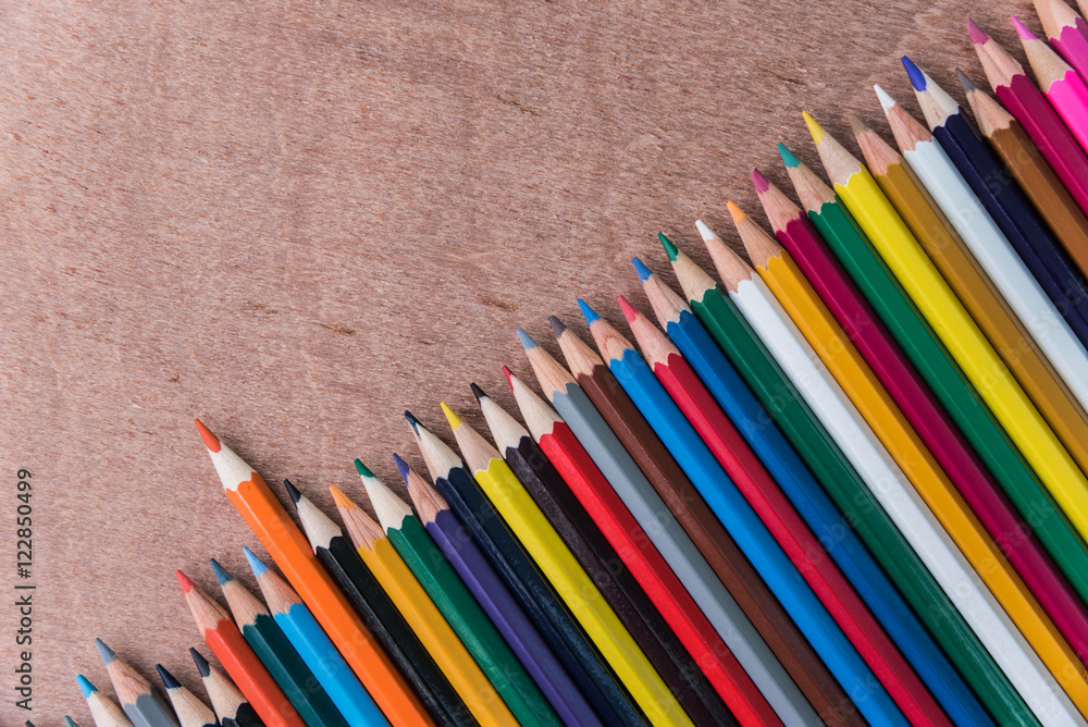 many color pencils on brown wood background many color pencils on brown wood background