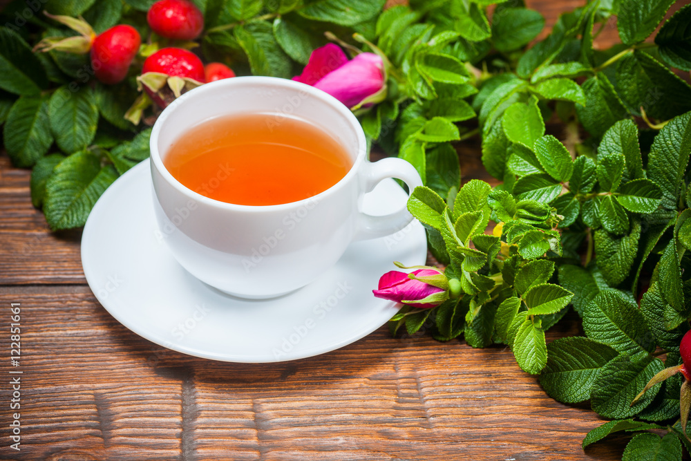 Healthy tea with a dogrose on wooden table Healthy tea with a dogrose on wooden table