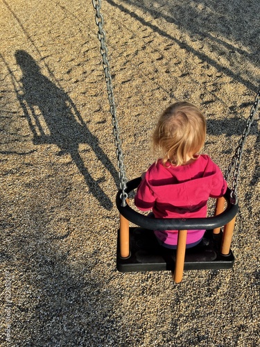 bambina in altalena e la sua ombra photo