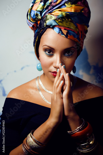 beauty bright african woman with creative make up, shawl on head like cubian closeup smiling photo