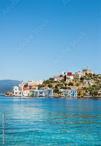 View over bay of Kastelorizo. Island coast with typical colorful Greek houses and clear turquoise sea water. Dodecanese, Greece