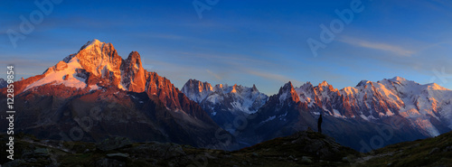 Photo Man enjoying the view of the Alps, with Aiguille Verte and Les Drus, near Chamonix during sunset