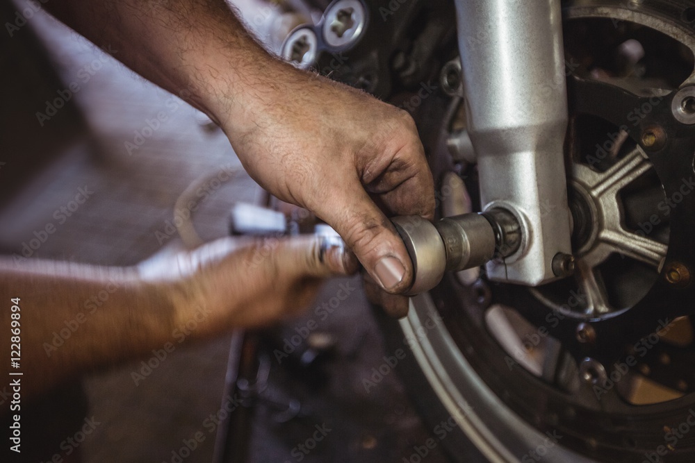 Mechanic examining a motorbike disc brake Mechanic examining a motorbike disc brake