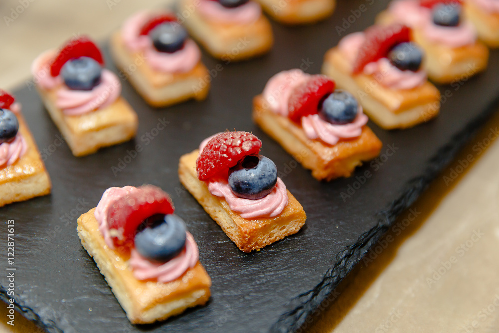 Little tasty coockies with berries lie on a wooden plate Little tasty coockies with berries lie on a wooden plate