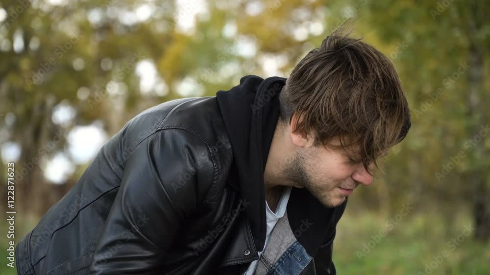 A young family with son at a picnic in the park on a sunny day.Family having picnic outdoors.Cute family picnicking in the park.Father pours tea on a picnic.Young smiling family doing a picnic on an