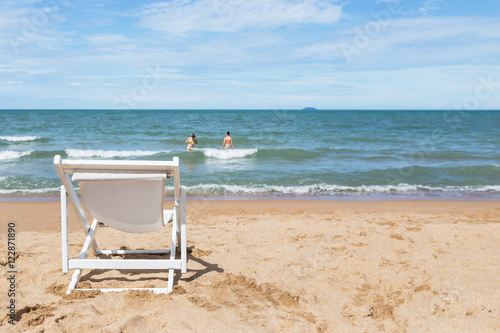 Empty white wooden beach chair on tropical beach