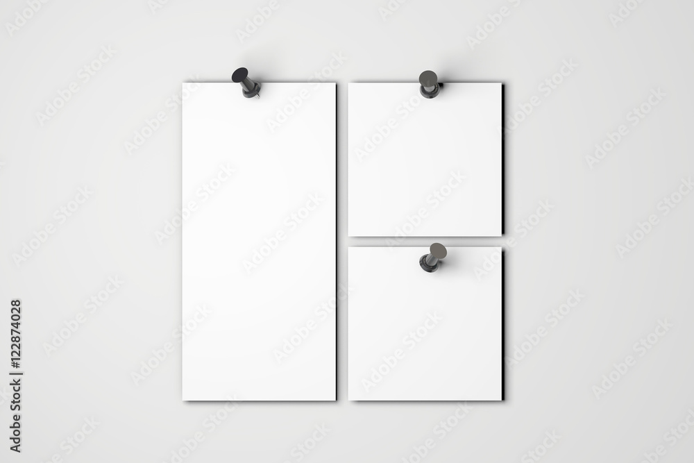 Blank white poster pinned to a plain wall with pushpins Blank white poster pinned to a plain wall with pushpins