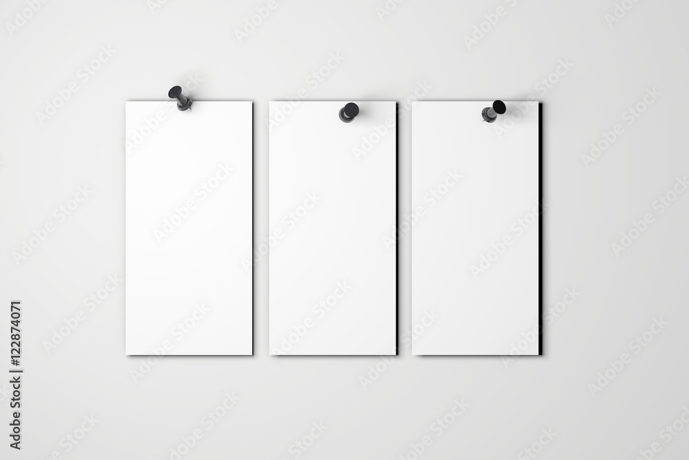 Blank white poster pinned to a plain wall with pushpins Blank white poster pinned to a plain wall with pushpins