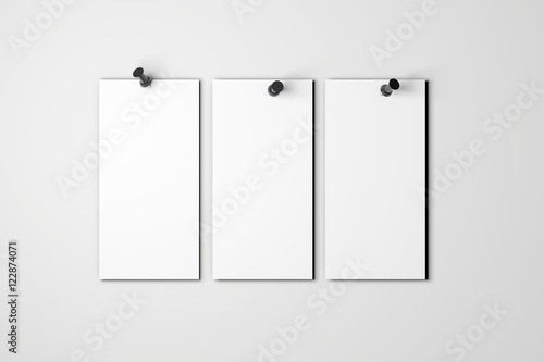 Blank white poster pinned to a plain wall with pushpins © ink drop