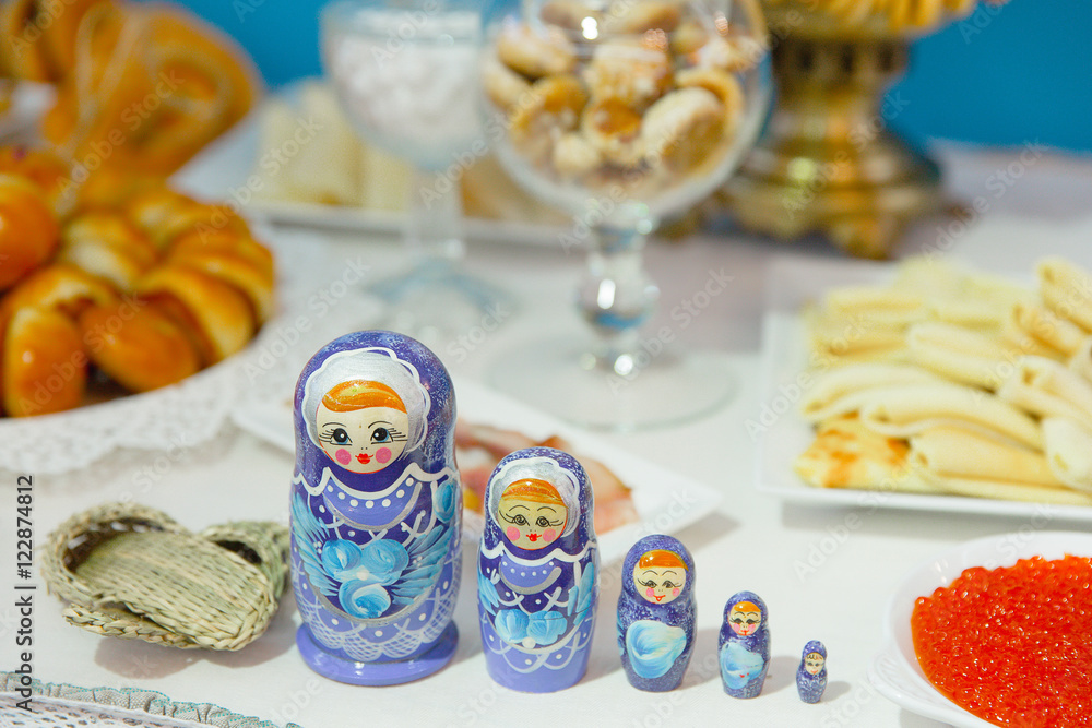 Table with sweets and appetizers decorated with Russian nestling