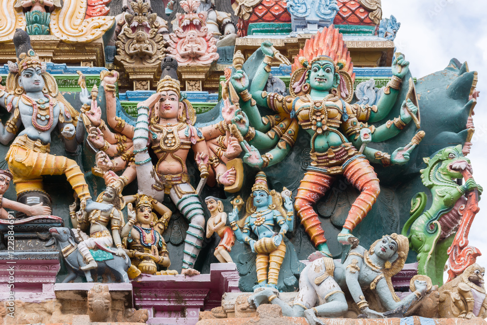 Madurai, India - October 19, 2013: Closeup of two images representing the fierce goddess Kali. In one she defeats the Man. Facade of South Gopuram at Meenakshi Temple.