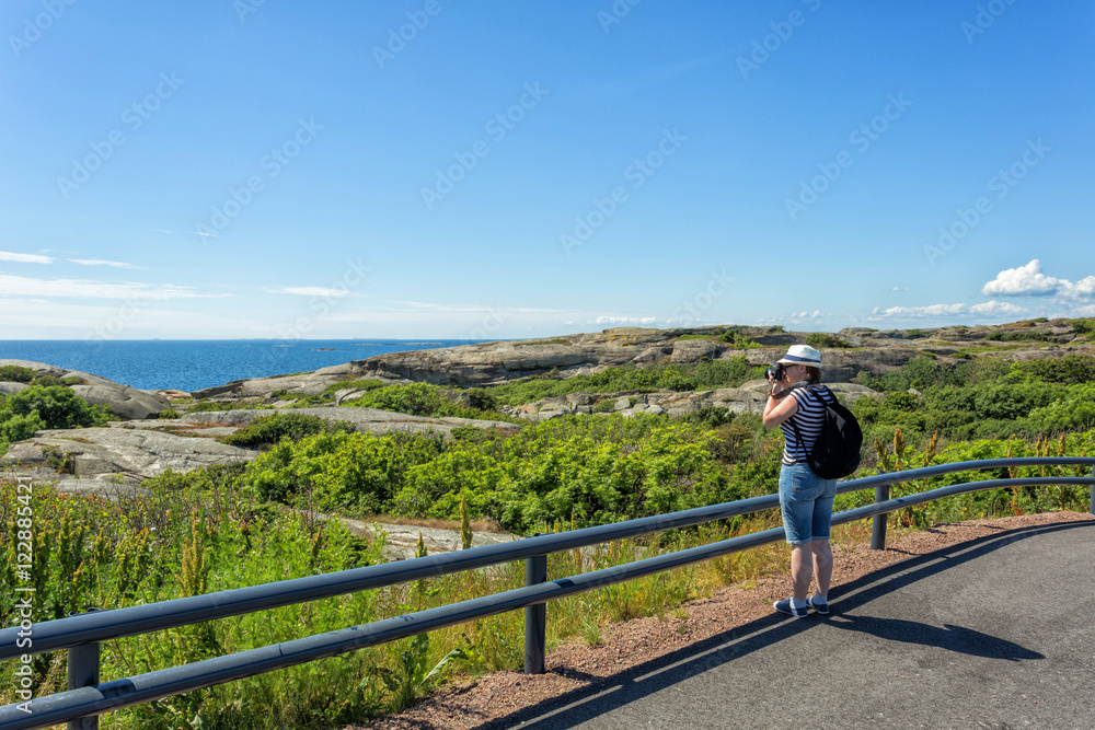 Beautiful young woman photographer hiker taking picture