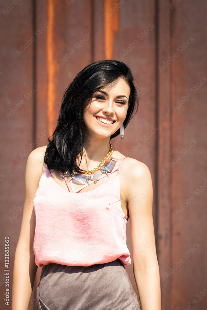 Fototapeta premium Beautiful girl stands near the wall