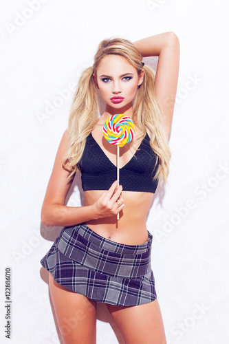 Φωτογραφία Sexy blonde woman with double pigtail posing with lollipop