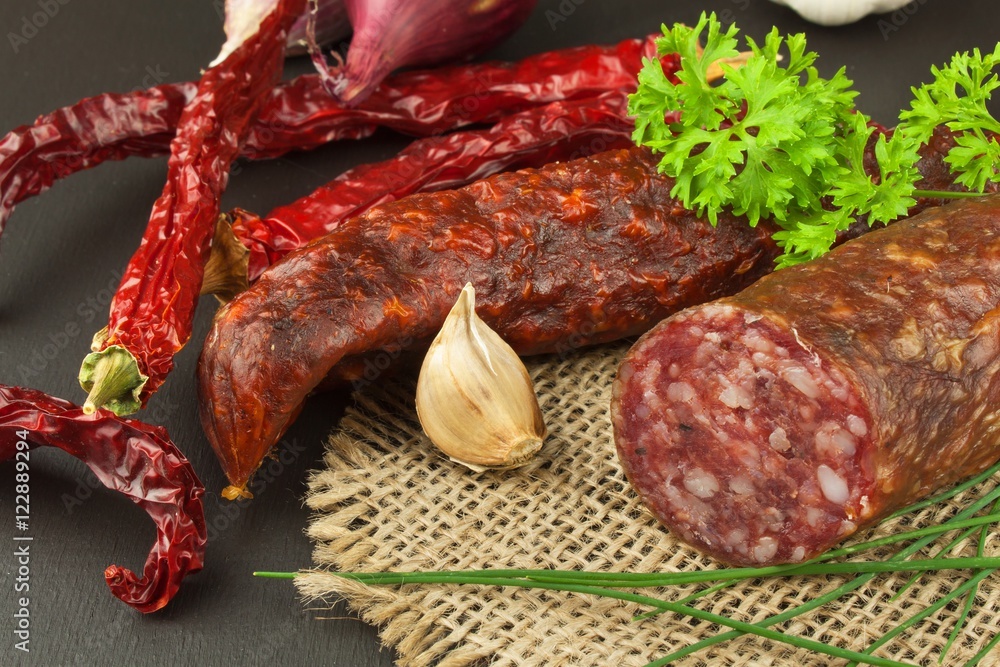 Dried sausages on wood. Homemade rustic sausages and chili. Sharp traditional food.
Dried sausages on wood. Homemade rustic sausages and chili. Sharp traditional food.