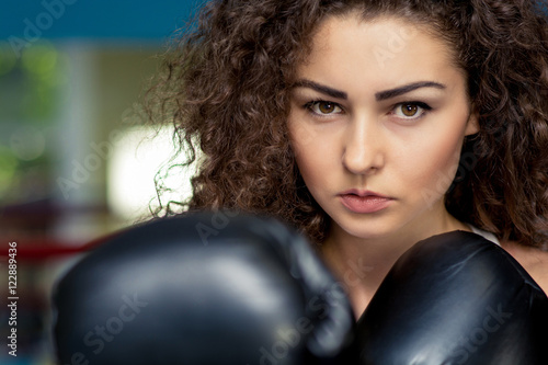 Woman in boxing gloves look at camera, ready to fight © patramansky
