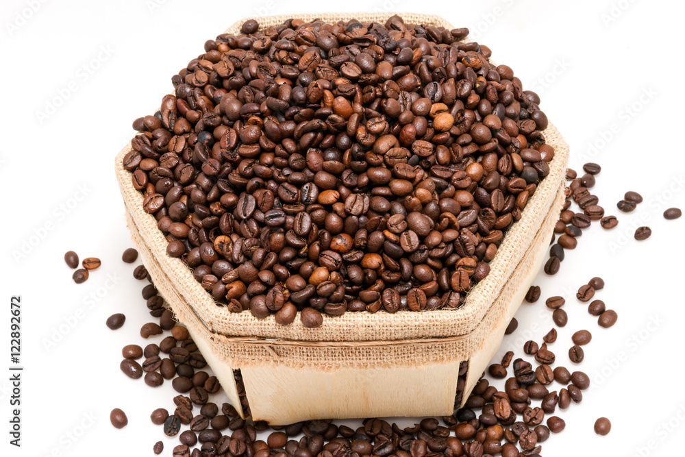 a lot of roasted coffee beans in a box made of natural materials on a white background a lot of roasted coffee beans in a box made of natural materials on a white background