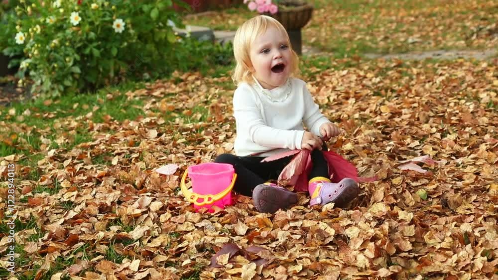 Cute baby girl playing with leaves in autumn Cute baby girl playing with leaves in autumn