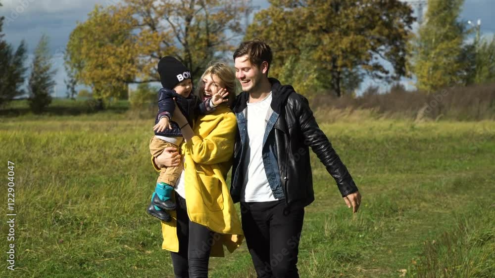 Happy mother, father and little son walking in autumn park and having fun.Happy young family spending time together outside in green nature.Happy family enjoying life together at meadow outdoor.Family Happy mother, father and little son walking in autumn park and having fun.Happy young family spending time together outside in green nature.Happy family enjoying life together at meadow outdoor.Family