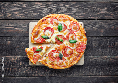 Pizza margarita on dark wood table