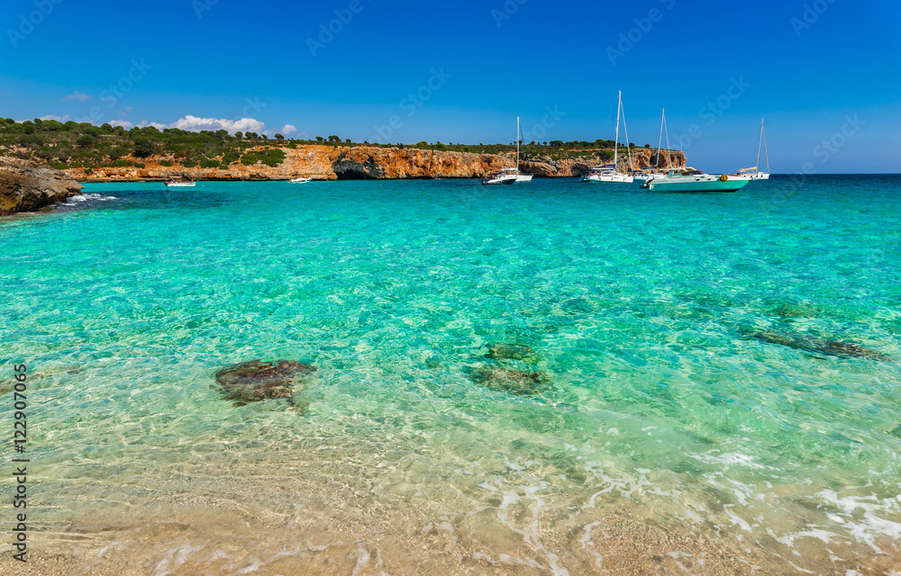Mediterranean Sea coastline beach bay with boats at Cala Varques Majorca Spain