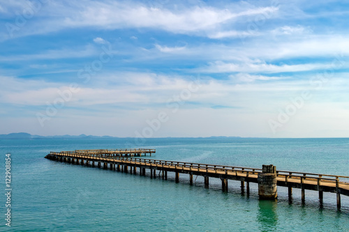 Port ferry boat with concrete ferry pier. Travel inspiration. Tropical landscape over sea with cloudy bright sky, Koh Chang island, Thailand.