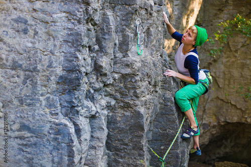 The girl climbs the rock.