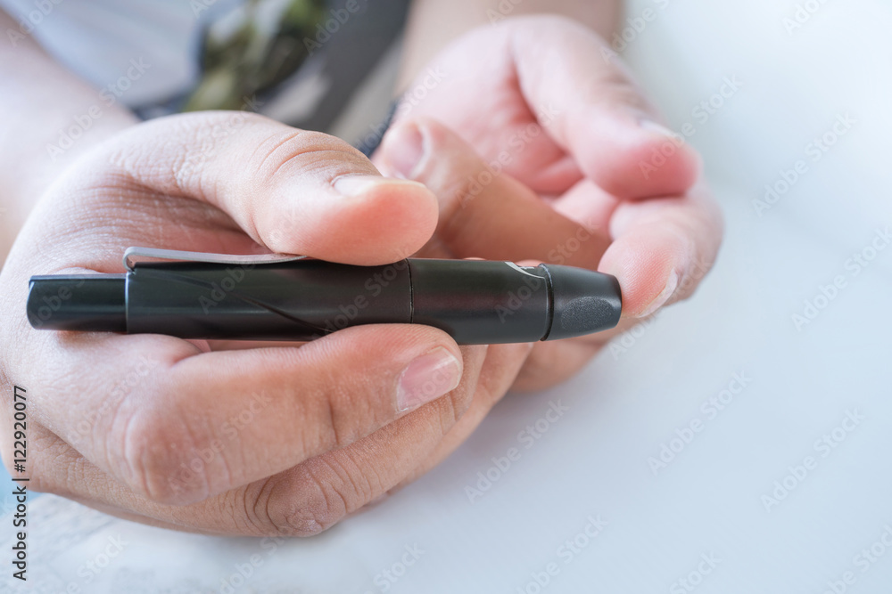 Close up of male finger patient pricking his finger to draw a d Close up of male finger patient pricking his finger to draw a d