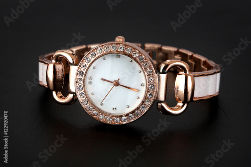 Gold watch with rhinestones . on a black background .