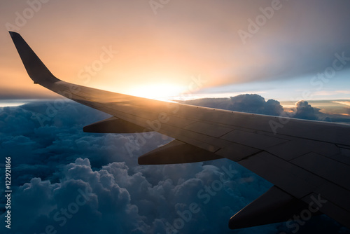 Wing of the plane on Sunset background and Cloud