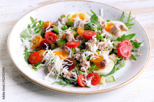 Fresh salad with fish, eggs and tomatoes in a plate.