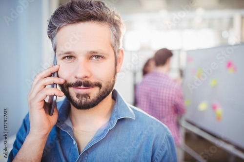 confident businessman listening to cellphone 