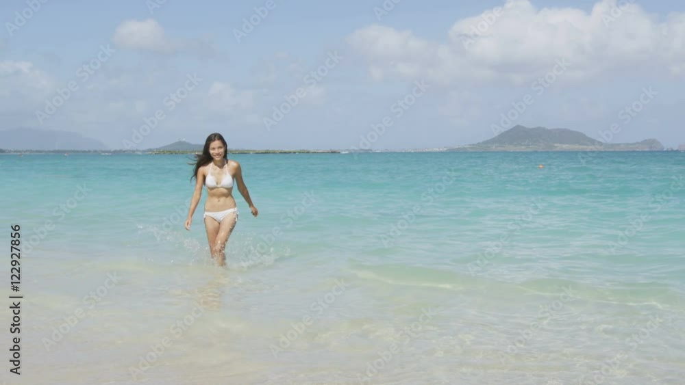 Beach bikini woman walking out of sea after swimming in the ocean on vacation travel getaway holidays. Beautiful young multiracial Asian Caucasian female model, 20s. RED EPIC SLOW MOTION, 96 FPS. Beach bikini woman walking out of sea after swimming in the ocean on vacation travel getaway holidays. Beautiful young multiracial Asian Caucasian female model, 20s. RED EPIC SLOW MOTION, 96 FPS.