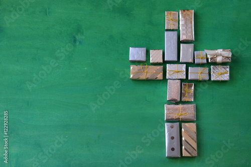 many little presents shaping a cross on green wooden background